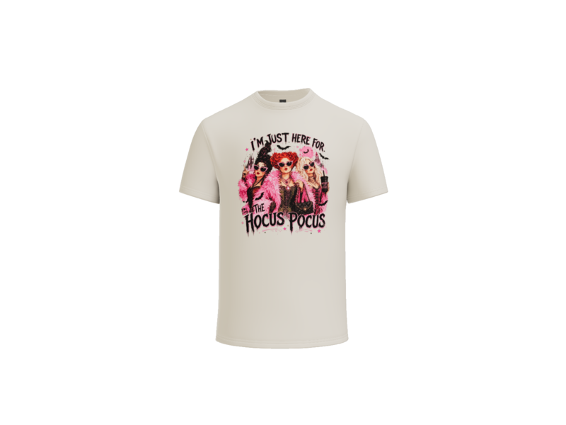 A cream-colored short-sleeve t-shirt with a colorful graphic print on the front featuring the text 'I'M JUST HERE FOR HOCUS POCUS' and stylized characters, shown against a plain white background.